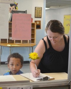 Denhamtown Elementary School pre-K4 student Brycen Magee, left, checks in at the office with his mother, Rhonda Magee Monday.
